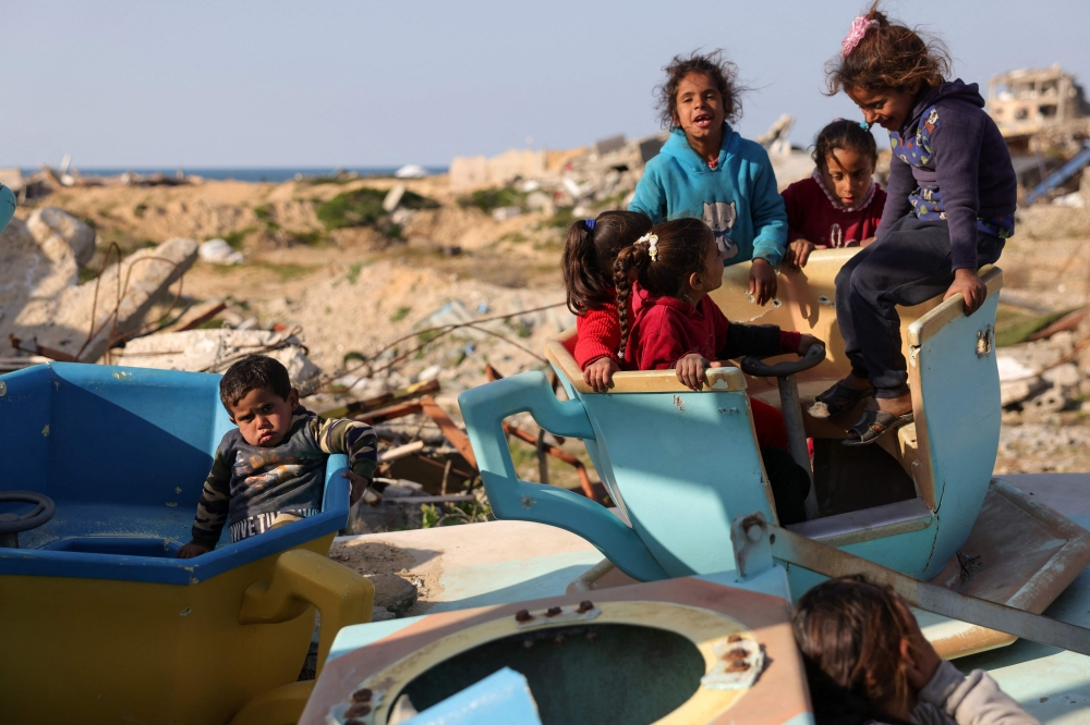 Palestinian children play in a war-damaged merry-go-round at the destroyed children’s park, west of Jabalia in the northern Gaza Strip. — Pic by AFP