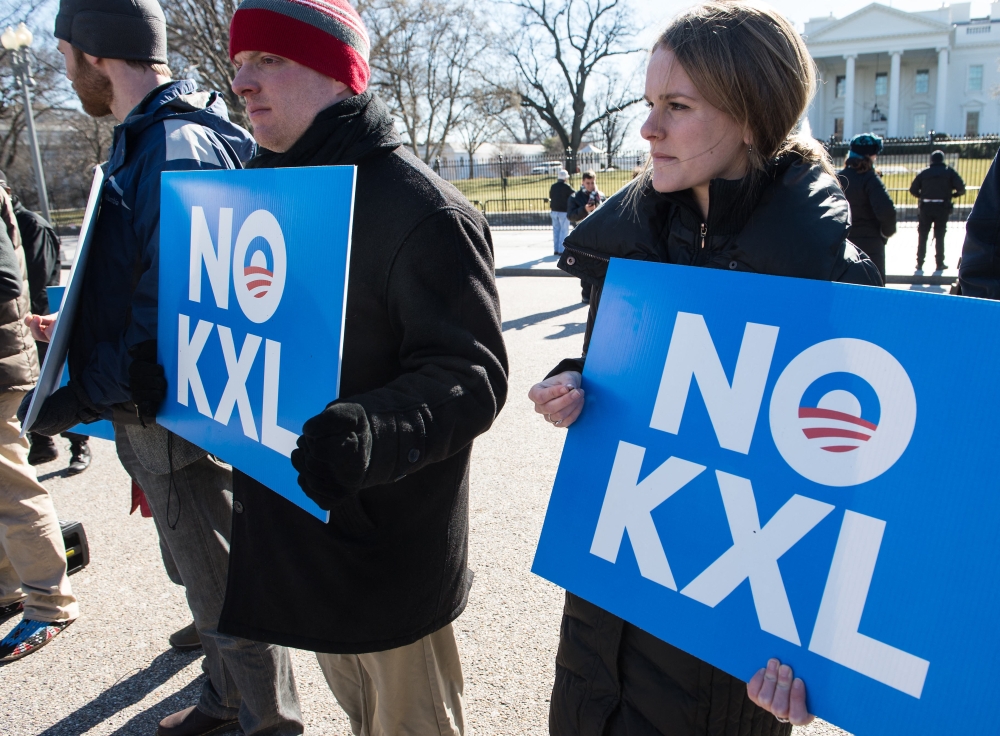 Demonstrators hold signs against the proposed Keystone XL pipeline from Canada to the Gulf of Mexico in front of the White House in Washington, DC, on January 28, 2015. — AFP pic