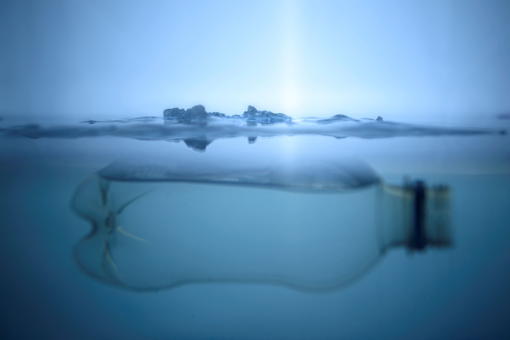 A plastic bottle floats below a layer of ice in Vaasa, Finland, on December 8, 2022. — AFP pic