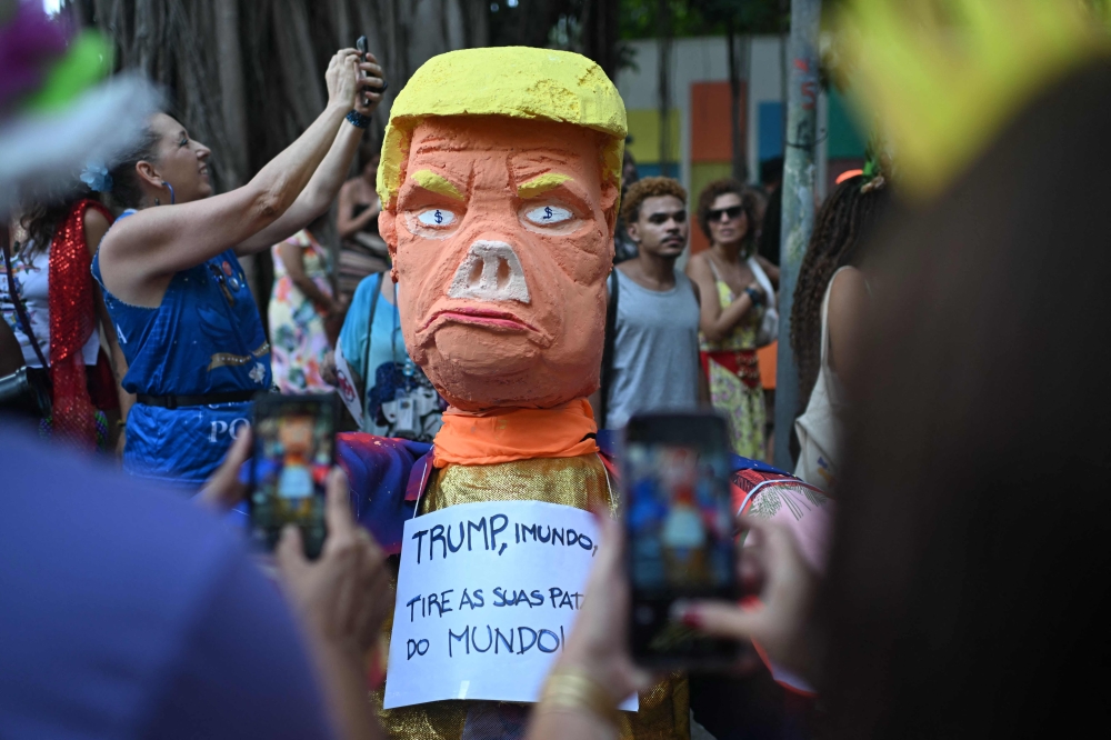 A puppet depicting US President Donald Trump with a sign reading ‘Trump, filth, get your paws off the world’ is pictured during a parade of the street carnival group Loucura Suburbana (Suburban Craziness) at the Engenho de Dentro neighborhood in the suburbs of Rio de Janeiro, Brazil. — Pic by AFP