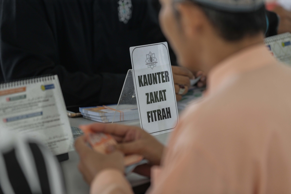 A person waits at a zakat payment counter at a mosque in Puncak Alam, Selangor, on June 20, 2023. — Picture by Sayuti Zainudin