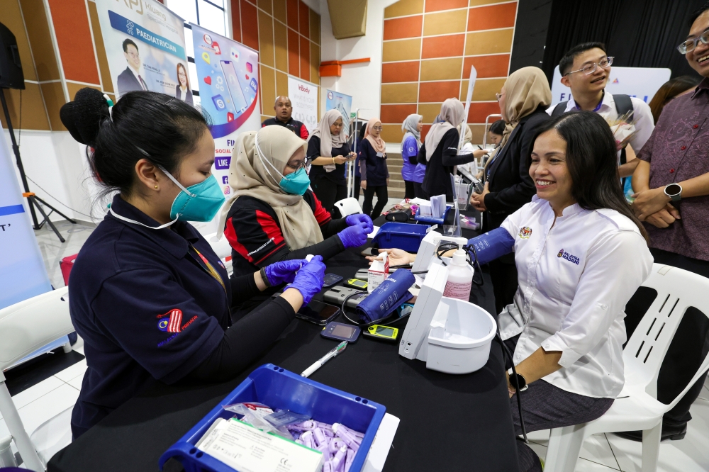 Deputy Minister of Communications who is also the Member of Parliament for Kulai, Teo Nie Ching (seated, right) performed a health check-up at the ‘Future Health 4 All: Health Connecting the People’ ceremony at Dewan Raya February 28, 2025. — Bernama pic