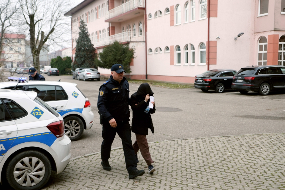 A Bosnian police officer escorts a suspect in child trafficking at the local prosecutor’s office, in North-Eastern town of Brcko, on February 27, 2025. — AFP pic 