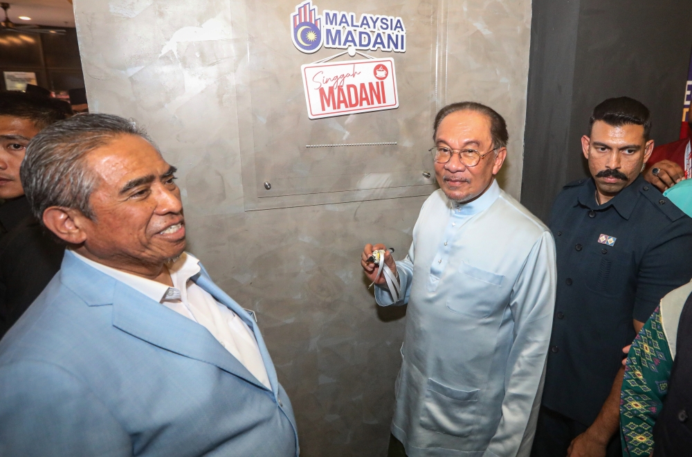 Prime Minister Datuk Seri Anwar Ibrahim (centre) pastes the Singgah Madani logo at the Putrajaya Nasi Kandar Restaurant chain at Liga Maju Putrajaya Nasi Kandar Restaurant, Persiaran Perdana, Precinct 2 February 28, 2025. — Bernama pic