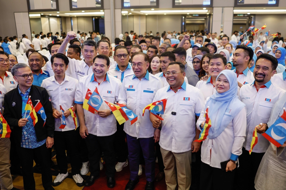 PKR president Datuk Seri Anwar Ibrahim (centre) flanked by his deputy Datuk Seri Rafizi Ramli (left) and vice-president Datuk Seri Amirudin Shari with Selangor PKR members. — Bernama pic