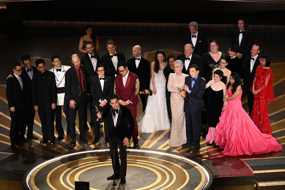 US film producer Jonathan Wang (centre) accepts the Oscar for Best Picture for ‘Everything Everywhere All at Once’ onstage during the 95th Annual Academy Awards at the Dolby Theatre in Hollywood, California March 12, 2023. — AFP pic