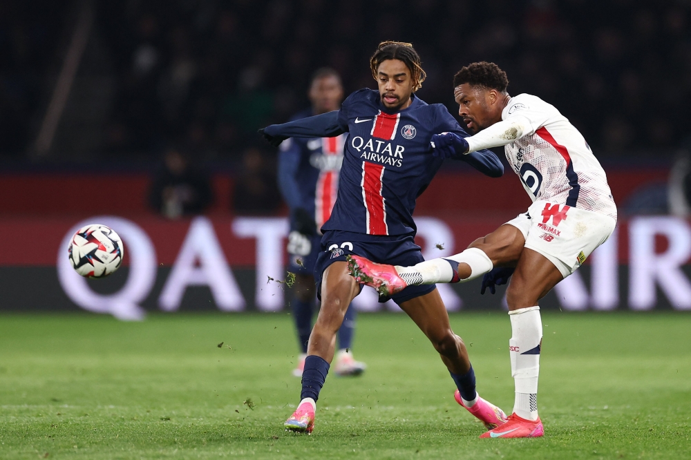 Paris Saint-Germain's Bradley Barcola (left) fights for the ball with Lille's Chuba Akpom (right). – Pic by AFP 