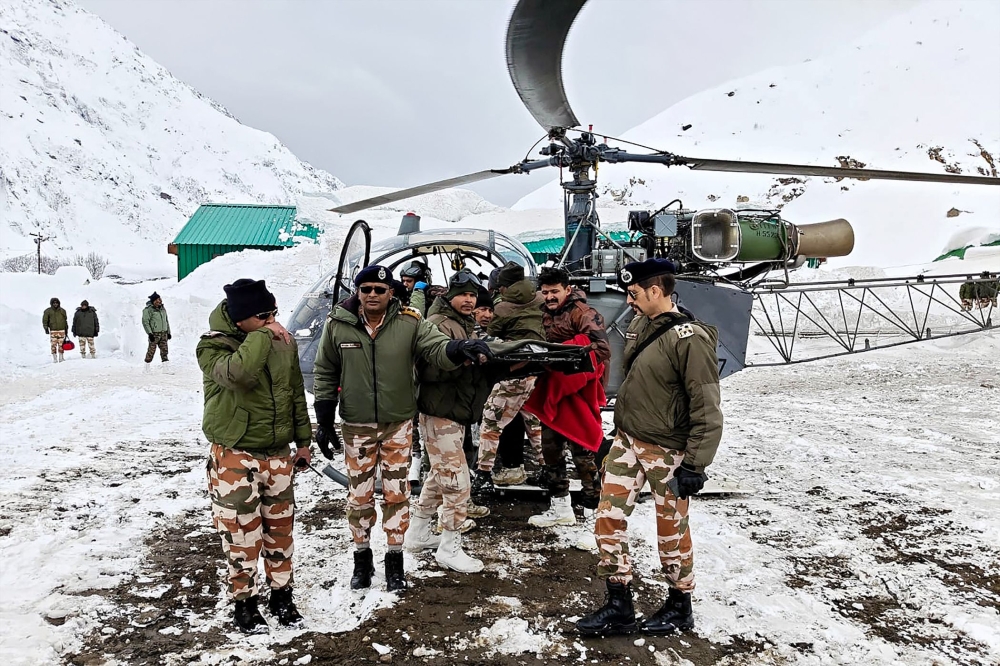 Security personnel carry a victim onto a helicopter during a rescue operation. — AFP pic/Department of Information and Public Relations (DIPR) Uttarakhand