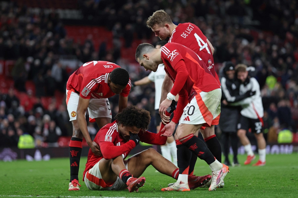 Manchester United's Dutch striker Joshua Zirkzee (C) consoled by teammates after missing the final penalty in the penalty shoot-out in the English FA Cup fifth round against Fulham. — AFP pic