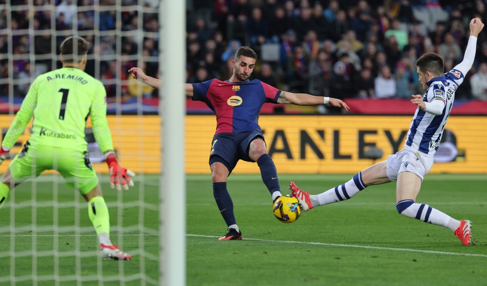 Barcelona's Spanish forward Ferran Torres (C) has an effort on goal despite being challenged by Real Sociedad's Spanish midfielder Igor Zubeldia (R) during the Spanish league football match between FC Barcelona and Real Sociedad. — AFP pic 
