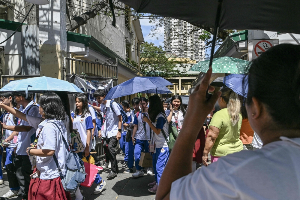 Philippine students in Manila on March 3, 2025 leave school after classes were suspended due to extreme heat. — AFP pic