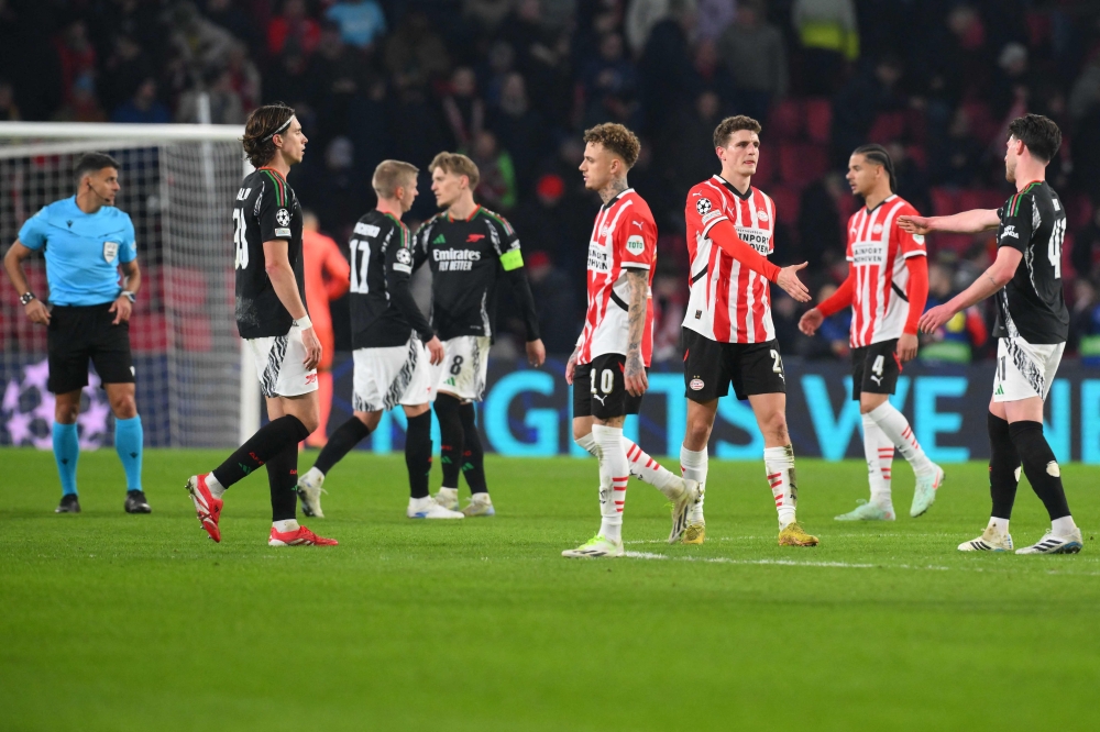 Arsenal and PSV players greet each other at the end of the UEFA Champions eague round of 16 first leg football match between PSV Eindhoven (NED) and Arsenal FC (ENG) at the the PSV Stadion. — AFP pic 