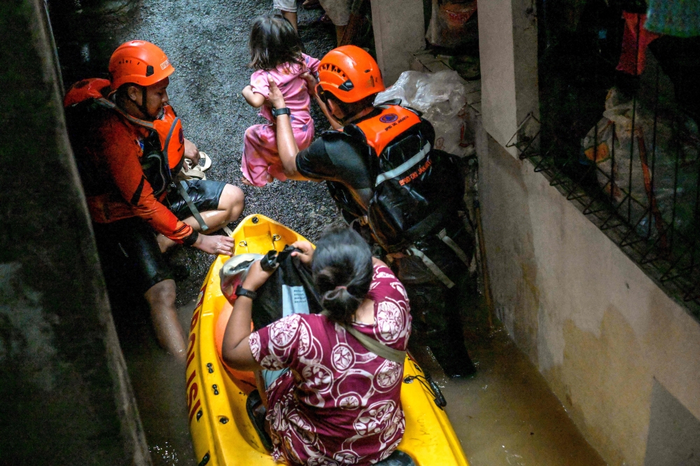 Rescue teams evacuate people whose homes have been flooded in Pasar Minggu district in Jakarta, Indonesia on March 4, 2025. — AFP pic