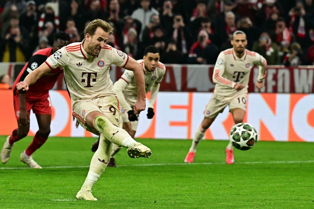 Bayern Munich's English Harry Kane scores from the penalty spot during the UEFA Champions League last 16, first-leg, football match against Bayer Leverkusen. — AFP