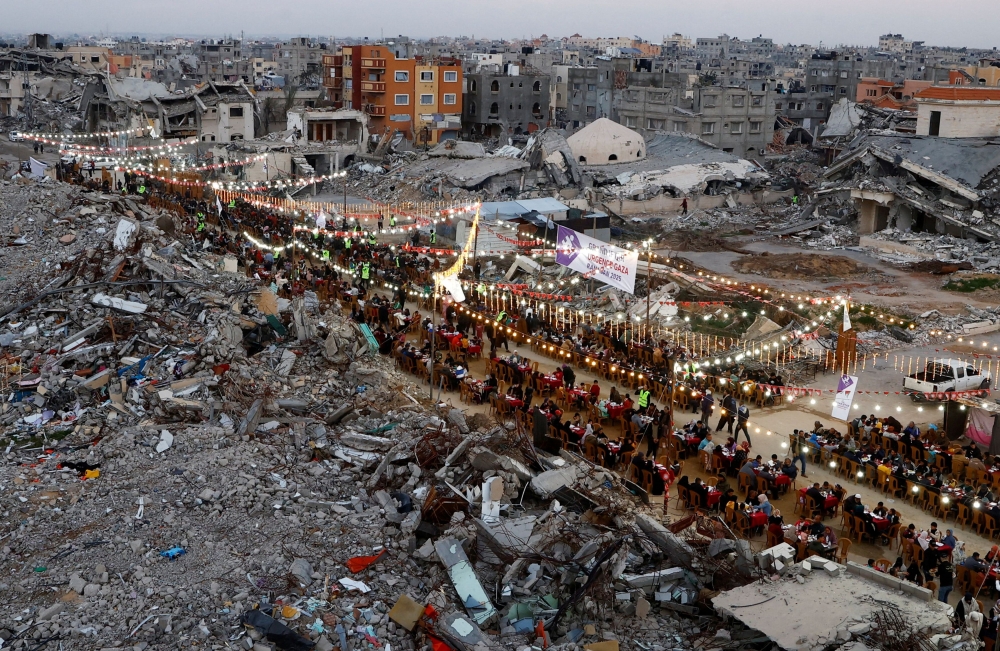 Palestinians break their fast by eating the Iftar meals during the holy month of Ramadan, near the rubble of buildings, amid a ceasefire between Israel and Hamas, in Rafah, in the southern Gaza Strip, March 1, 2025. — Reuters pic 