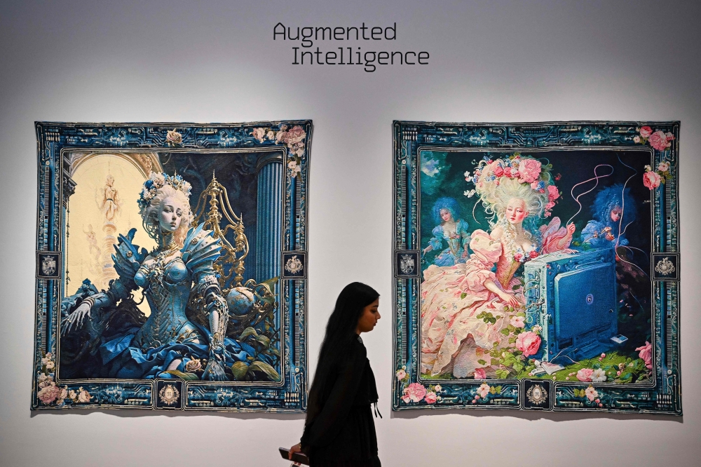 A person walks past AI artwork created by Grimes, Mac Boucher, Mary Jacobo and Eurypheus called ‘Marie Antoinette After the Singularity #1 and Marie Antoinette After the Singularity #2’ at a press preview for ‘Augmented Intelligence’ at Christie’s on February 20, 2025 in New York City. — AFP pic