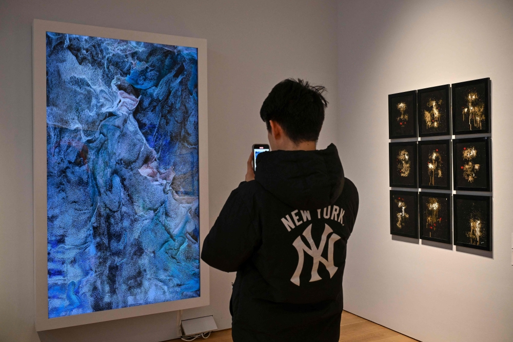 A person looks at AI artwork created by Refik Anadol called ‘Machine Hallucinations - ISS Dreams - A’ at a press preview for ‘Augmented Intelligence’ at Christie’s on February 20, 2025 in New York City. Christie's first auction of art made by artificial intelligence (AI) ended March 5, 2025, with mixed results, providing scant clues as to the future of the new and controversial medium. — AFP pic