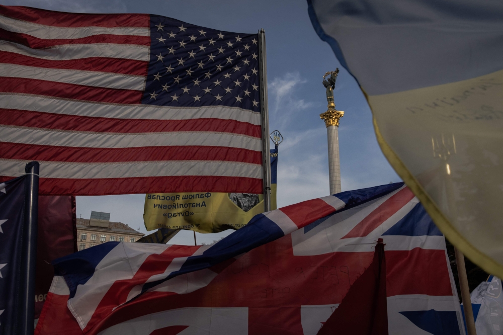 US, UK and Ukrainian flags are seen at a makeshift memorial for the fallen Ukrainian and foreign fighters on the Independence Square in Kyiv. — AFP pic