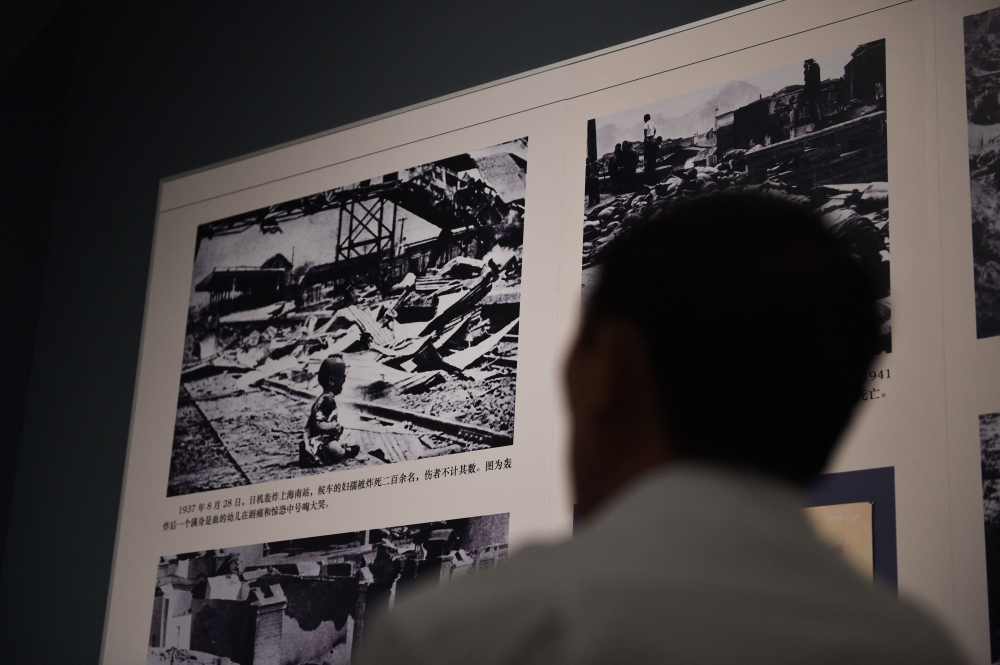 A visitor looks at the 'Bloody Saturday' famous photo by Chinese newsreel photojournalist H. S. Wong, which depicts a baby crying at Shanghai South Railway Station after a Japanese bombing attack on the city in 1937, at an exhibition about World War II in Beijing on September 3, 2014.  — AFP pic