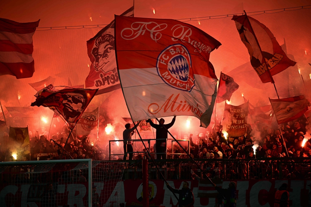 Bayern Munich fans light flares and wave flags prior to the UEFA Champions League last 16, first-leg, football match Fwith Bayer 04 Leverkusen on March 5, 2025 in Munich, southern Germany. — AFP pic