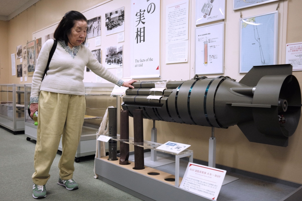 In this photo taken on February 27, 2025, Shizuko Nishio, who will turn 86 on March 10, when Japan will commemorate 80 years after the bombing of Tokyo, shows a model of an incendiary bomb that was mainly used in the air raid on March 10, 1945, at The Centre of the Tokyo Raids and War Damage in Tokyo. — AFP pic