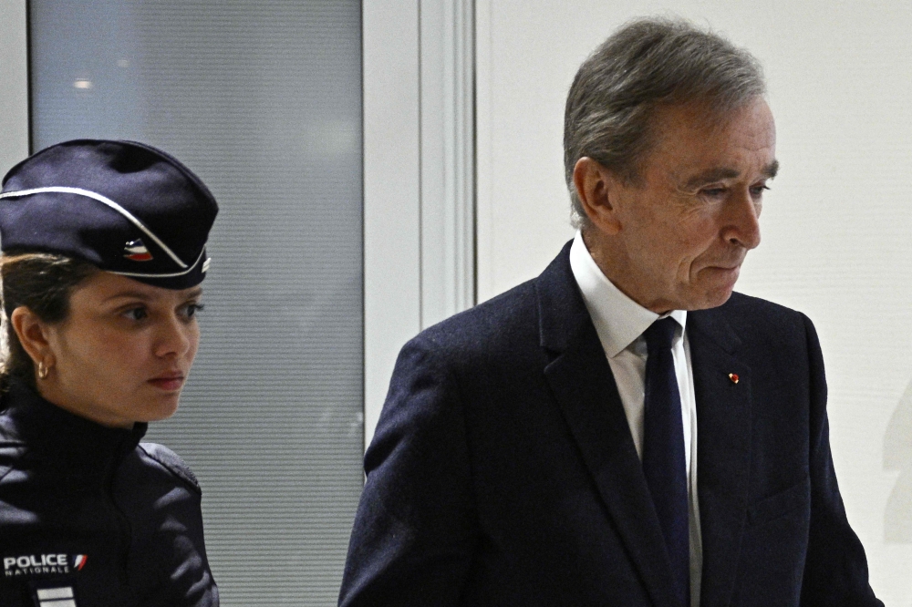 LVMH CEO Bernard Arnault (right) leaves the Paris courthouse after testifying in influence-peddling trial against former French intelligence head of internal security Bernard Squarcini, in Paris November 28, 2024. — AFP pic
