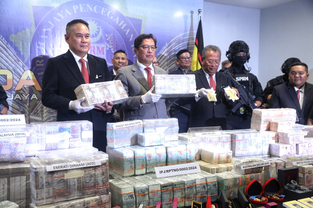 Malaysian Anti-Corruption Commission (MACC) Chief Commissioner Tan Sri Azam Baki holding RM 1 million that was seized from Datuk Seri Ismail Sabri Yaakob at the press conference in MACC HQ, Putrajaya. March 3, 2025. — Picture by Choo Choy May