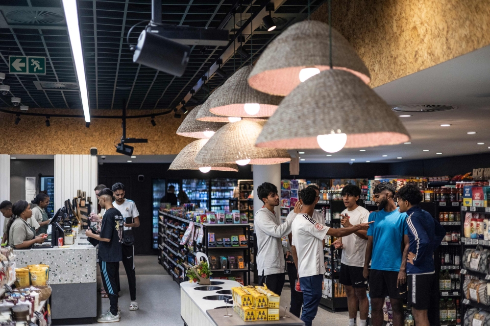 Young people gather as others pay at the cashier at Pantry, a hybrid model of petrol station, supermarket, deli, take-away and retail store in Rosebank, Johannesburg, on February 28, 2025. — AFP pic