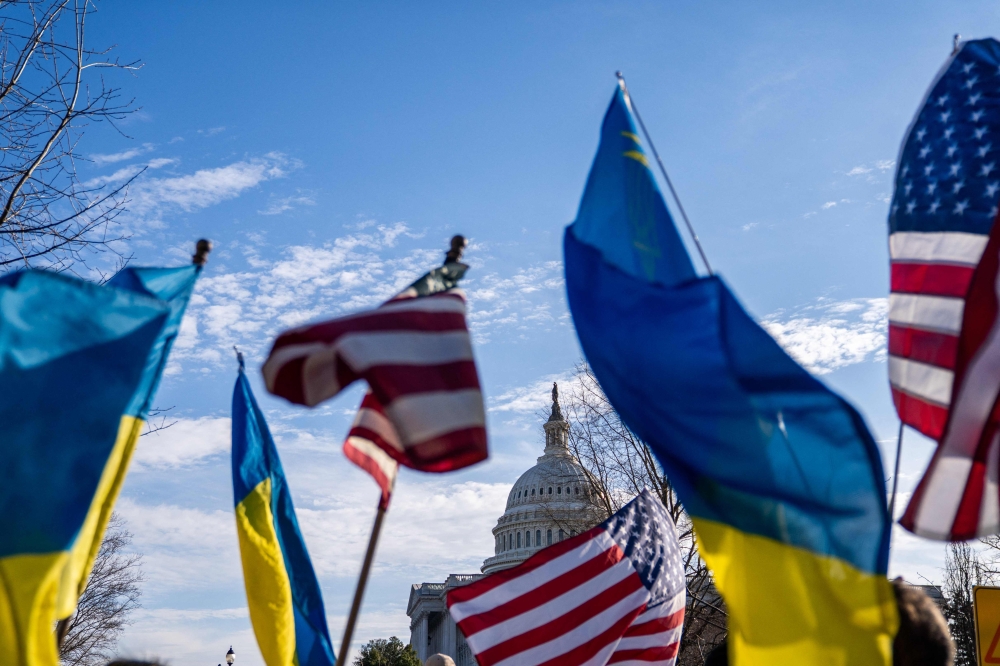 People wave US and Ukrainian flags during a rally in support of Ukraine ahead of US President Donald Trump's address to a joint session of Congress in Washington, DC, on March 4, 2025. — AFP pic