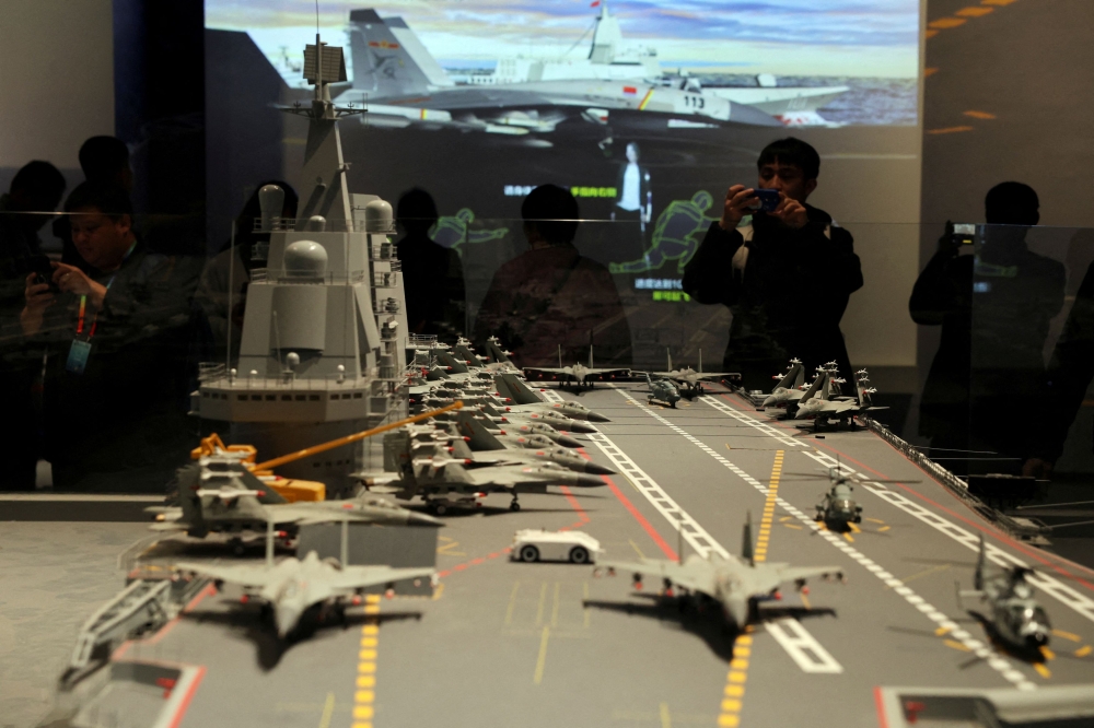 Visitors look at a replica of Liaoning aircraft carrier displayed at the PLA Naval Museum, on the 75th founding anniversary of the Chinese People's Liberation Army (PLA) Navy, in Qingdao, Shandong province April 23, 2024. — Reuters pic  