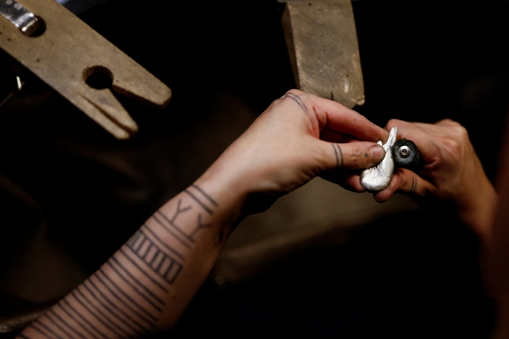 Greenlandic goldsmith Nadja Arnaaraq Kreutzmann works on a shrimp-shaped earring in her workshop in Nuuk, Greenland, February 9, 2025. — AFP pic