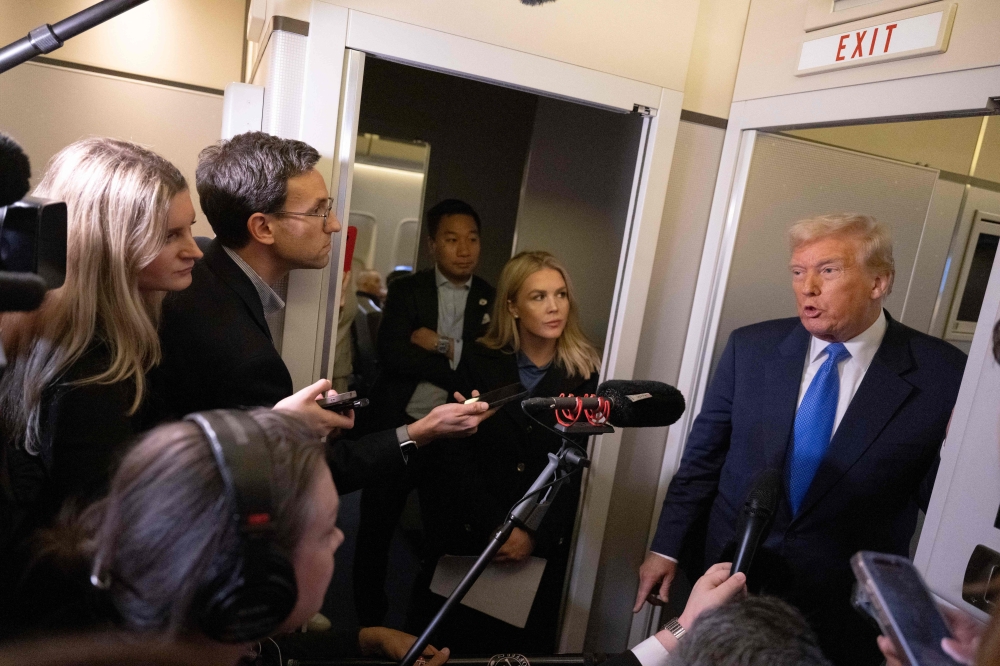 US President Donald Trump speaks to journalists aboard Air Force One as he travels from West Palm Beach back to Washington on March 9, 2025. — AFP pic