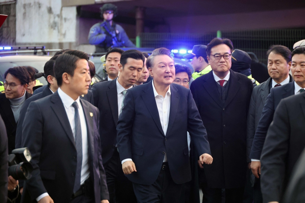 Impeached South Korean President Yoon Suk Yeol reacts to his supporters as he arrives at the presidential residence in Seoul on March 8, 2025. Impeached South Korean President Yoon Suk Yeol was released from detention on March 8, after a court voided his arrest on procedural grounds -- but he remains under investigation over his declaration of martial law. — Yonhap pic via AFP