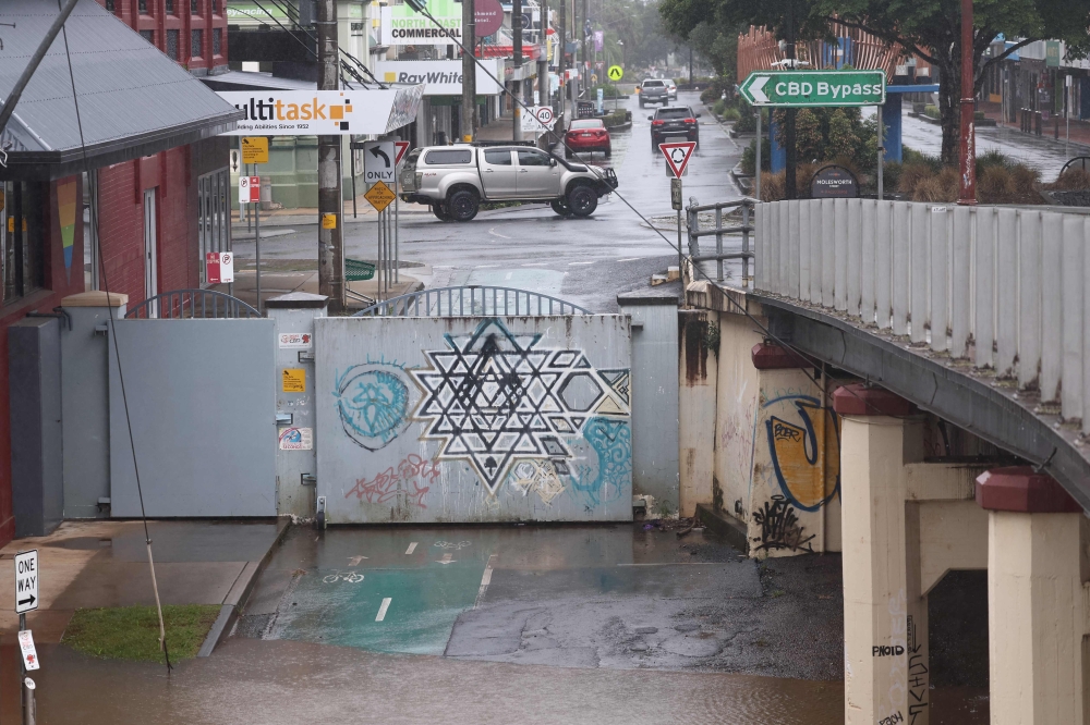 Floodwaters reach the levee walls holding back the Wilsons River in Lismore on March 9, 2025. — AFP pic