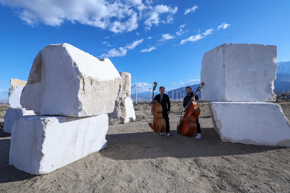 Musicians pose at Mexican artist Jose Davila’s ‘The Act of Being Together,’ composed of stacked 16-tonne marble boulders that were quarried in the Chihuahua Northern Desert, during the media preview day of the Desert X exhibit. — AFP pic 