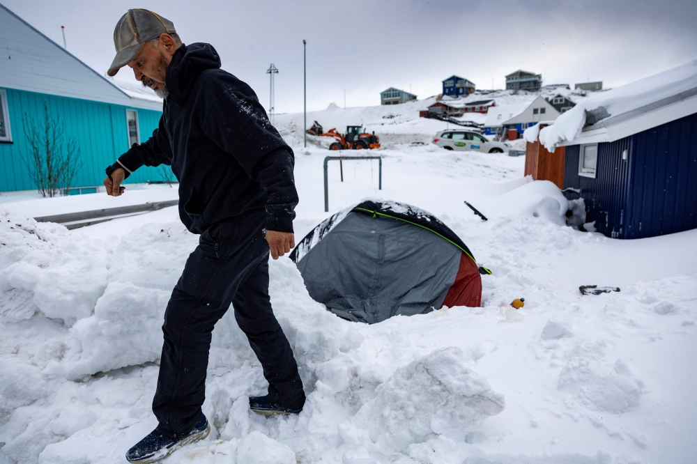 Rough sleeper Anders Maqe is seen next his tent surrounded by snow in Nuuk, Greenland, on March 6, 2025. — AFP pic
