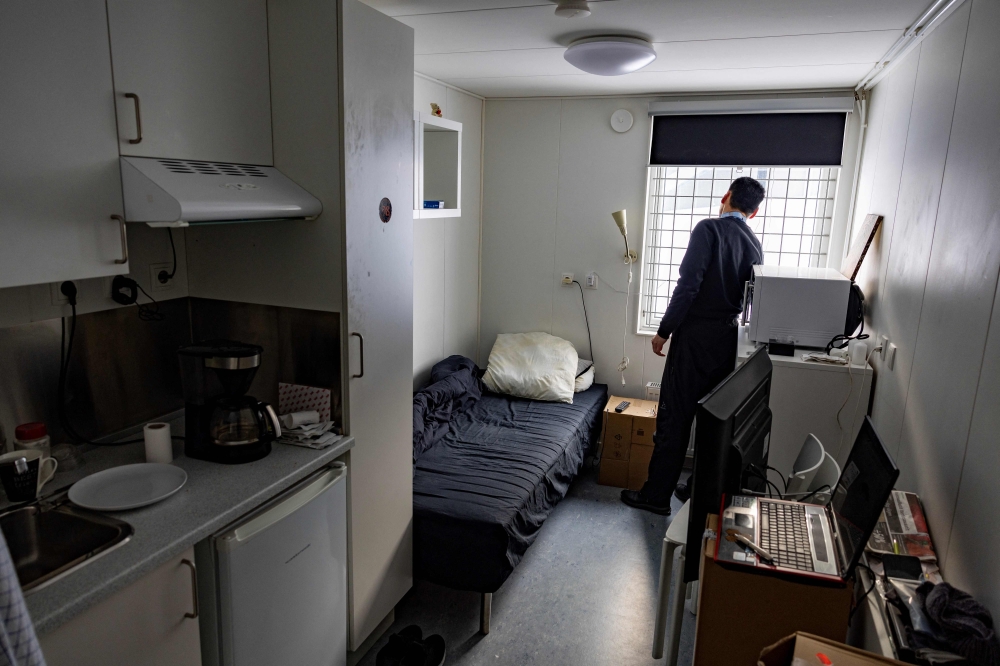 Aage, a 54-year-old homeless man, looks out from the window of his temporary home in a container shelter in Nuuk, Greenland, on March 7, 2025. — AFP pic