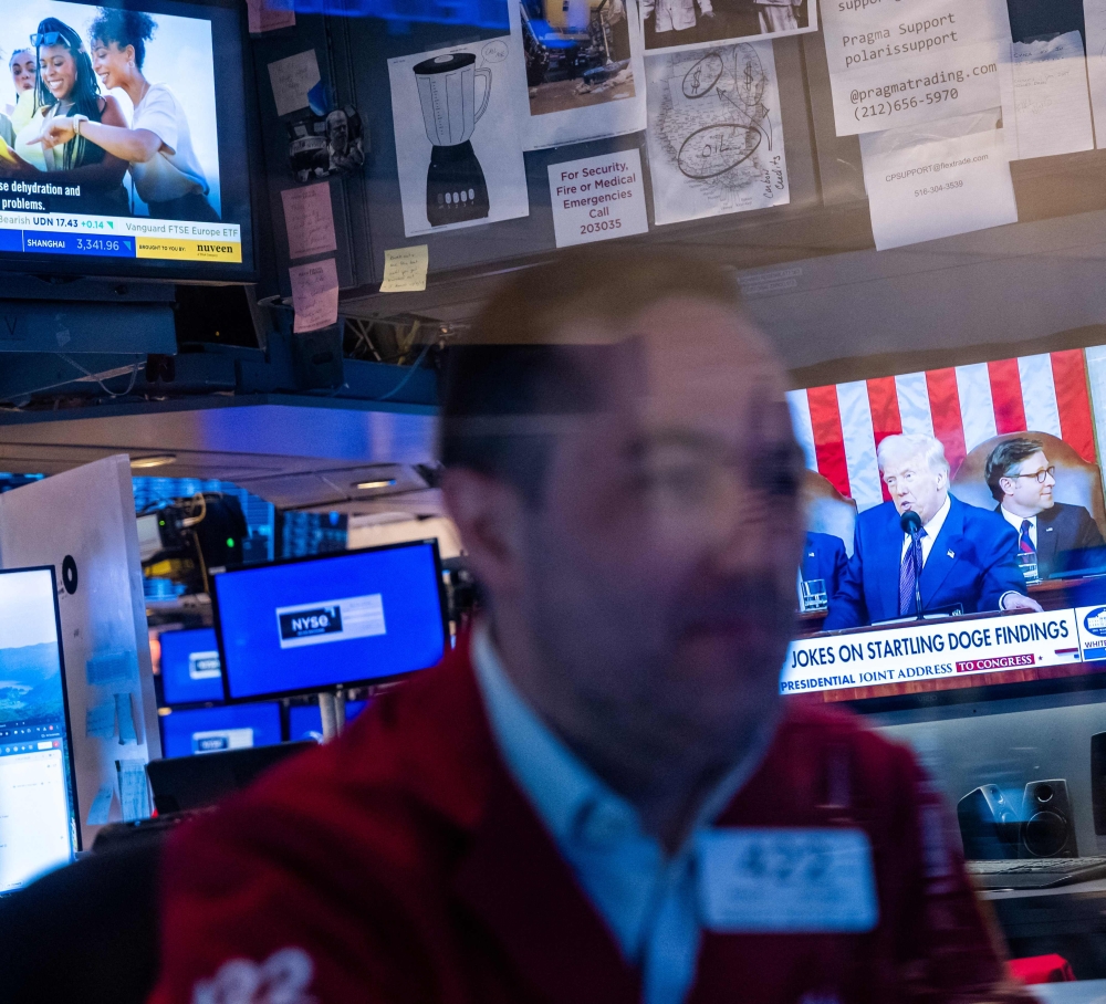 Donald Trump appears on a television screen as traders work on the floor of the New York Stock Exchange (NYSE) in New York City March 05, 2025. — AFP pic 