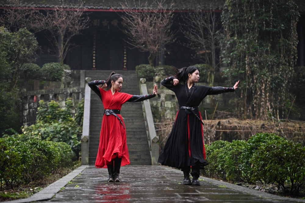 This photo taken on February 21, 2025 shows Duan Ruru (left), a founding member of the Emei Kung Fu Girls, and Liu Qiao demonstrating their martial art movements at the Zhongfei temple in Emeishan. The ancient Emei school in the mountains of Sichuan is thought to have welcomed a higher proportion of women and girls, but has struggled in recent years to raise its profile. That is now changing thanks to a group of women from Generation Z, who mesh skilful swordwork with social media smarts to help put the sect back on the map. — AFP pic 