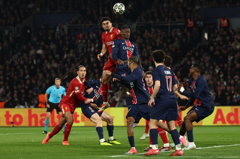 Liverpool's Luis Diaz (centre left) and Paris Saint-Germain's Nuno Mendes (centre right) fight for the ball in the air during the UEFA Champions League Round of 16 first leg football match at the Parc des Princes stadium in Paris on March 5, 2025. — AFP pic