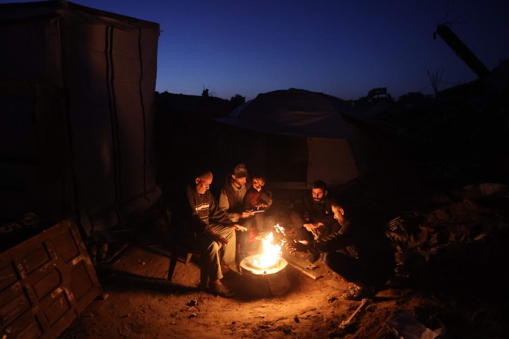 Palestinians gather around a fire to keep warm in Jabalia in the northern Gaza Strip on March 10, 2025, during the Muslim holy fasting month of Ramadan. — AFP pic 