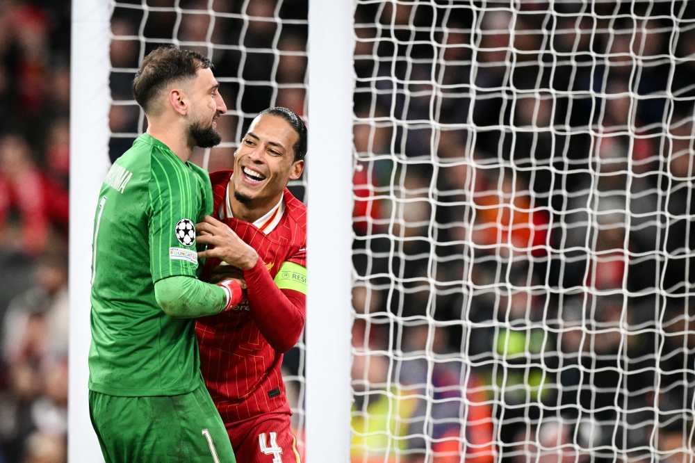 Paris Saint-Germain's Italian goalkeeper #01 Gianluigi Donnarumma (L) laughs with Liverpool's Dutch defender #04 Virgil van Dijk (R) during the last 16 second leg UEFA Champions League football match between Liverpool and Paris Saint-Germain (PSG). — AFP pic