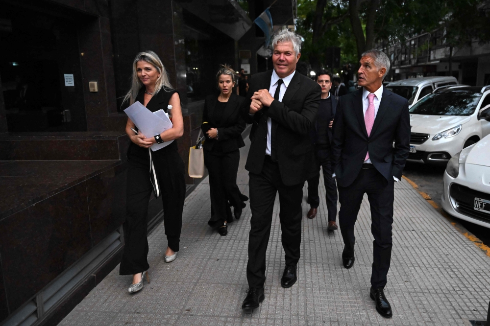 Fernando Burlando (C), lawyer for Dalma and Giannina Maradona, daughters of Argentine football legend Diego Maradona, leaves the courtroom at the end of the first day of the Maradona death trial in San Isidro, Buenos Aires province yesterday. — AFP pic 