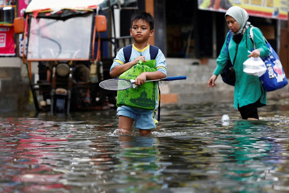 People walk through water at a flooded area affected by rising sea levels and land subsidence in North Jakarta, Indonesia, November 20, 2024. China’s eastern city of Hangzhou and Indonesia’s capital of Jakarta topped the list of cities suffering from ‘climate whiplash’, or a rapid succession of prolonged floods and droughts, the study showed. — Reuters pic 