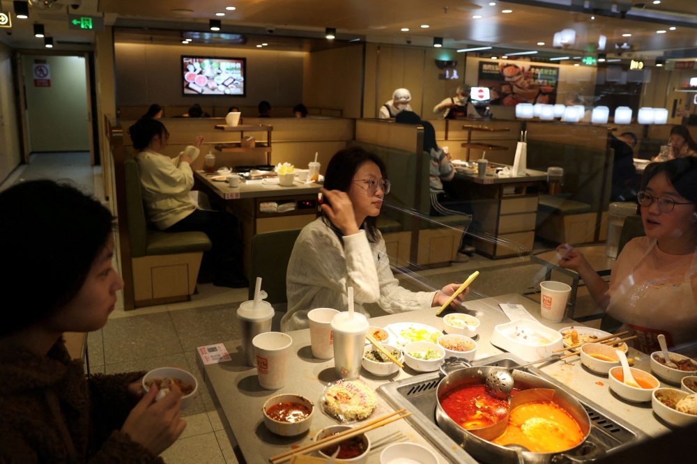 Customers dine at the Hailao Huoguo, a new hotpot chain by Haidilao, in Beijing, China December 10, 2023. The Chinese hotpot giant said it would compensate over 4,000 diners who had visited one of its outlets in Shanghai after two diners urinated into their hotpot broth. — Reuters pic 