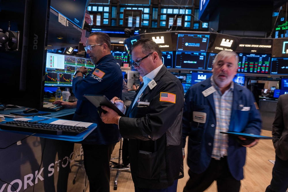 Traders work on the floor of the New York Stock Exchange in New York March 12, 2025. — AFP pic