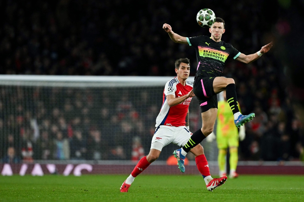 PSV Eindhoven’s Croatian forward #05 Ivan Perisic (R) jumps for the ball against Arsenal’s Polish defender #15 Jakub Kiwior (L) during the UEFA Champions League Round of 16 second-leg match at the Emirates Stadium in London. — AFP pic