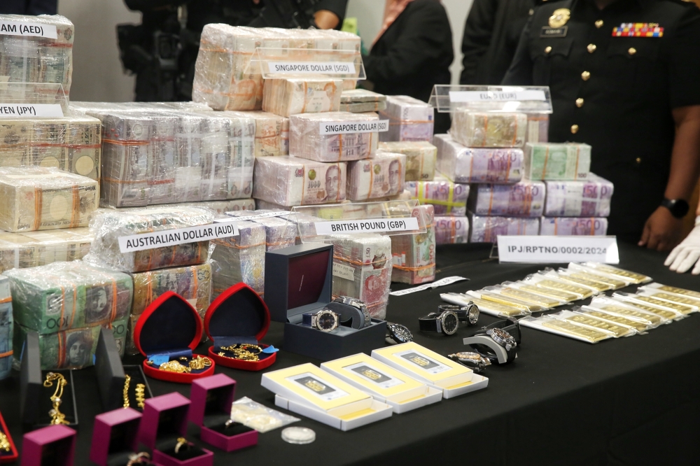 Cash in various currencies as well as gold and jewellery seized for the investigation linked to Datuk Seri Ismail Sabri Yaakob is displayed during a press conference in Putrajaya on March 3, 2025. — Picture by Choo Choy May.