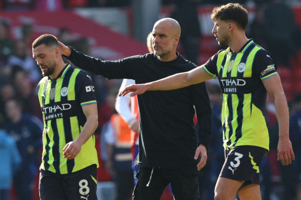 Manchester City's manager Pep Guardiola (centre) consoles midfielder Mateo Kovacic (left) after the English Premier League football match with Nottingham Forest at The City Ground in Nottingham, central England, on March 8, 2025. — AFP pic