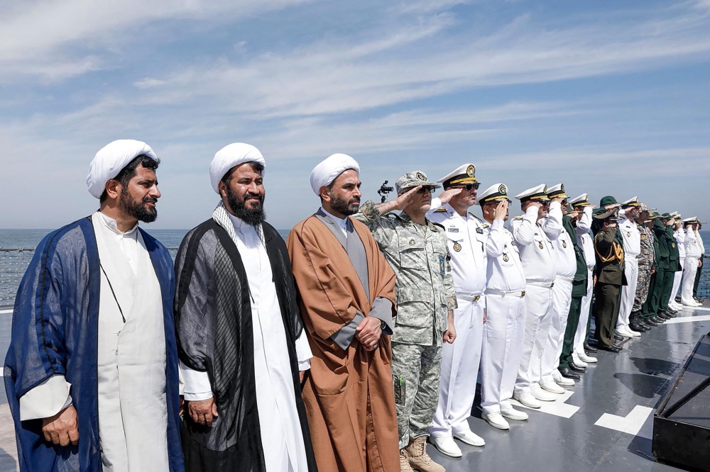 This handout photo made available by the Iranian Army Office on March 12, 2025 shows local officials and navy personnel attending a joint Iranian-Russian-Chinese military drill in the Gulf of Oman. The navies of Iran, Russia and China are holding military drills off the coast of Iran this week in a bid to boost cooperation, according to Iranian media. — Iranian Army Office handout pic via AFP